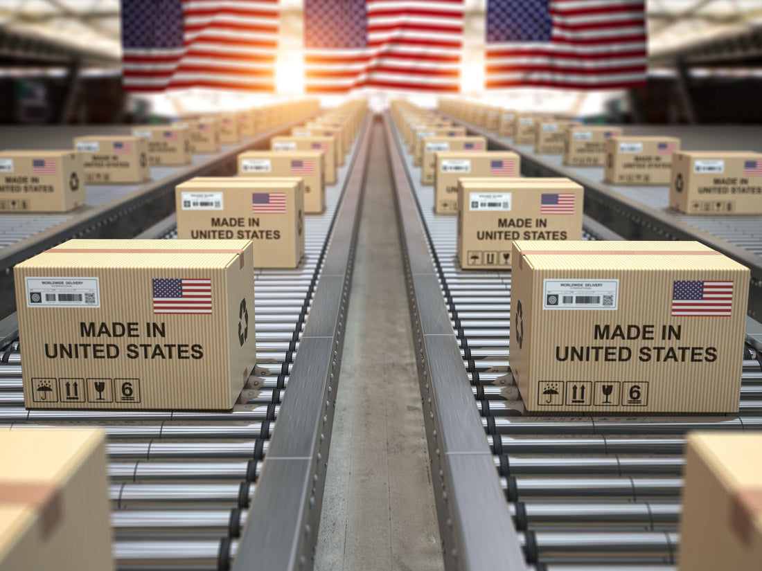 Conveyor belt carrying boxes labeled “Made in the USA,” representing American manufacturing costs rising under tariffs.